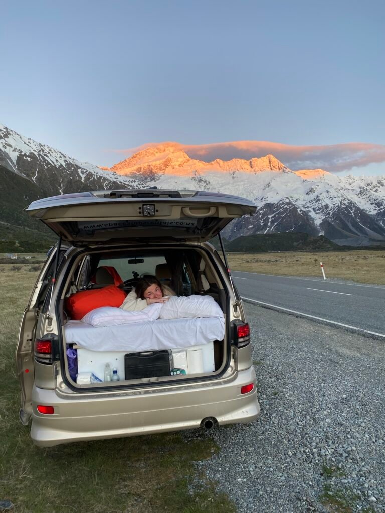 Léa au réveil dans le van garé au bord de la route avec la vue sur le Mont Cook